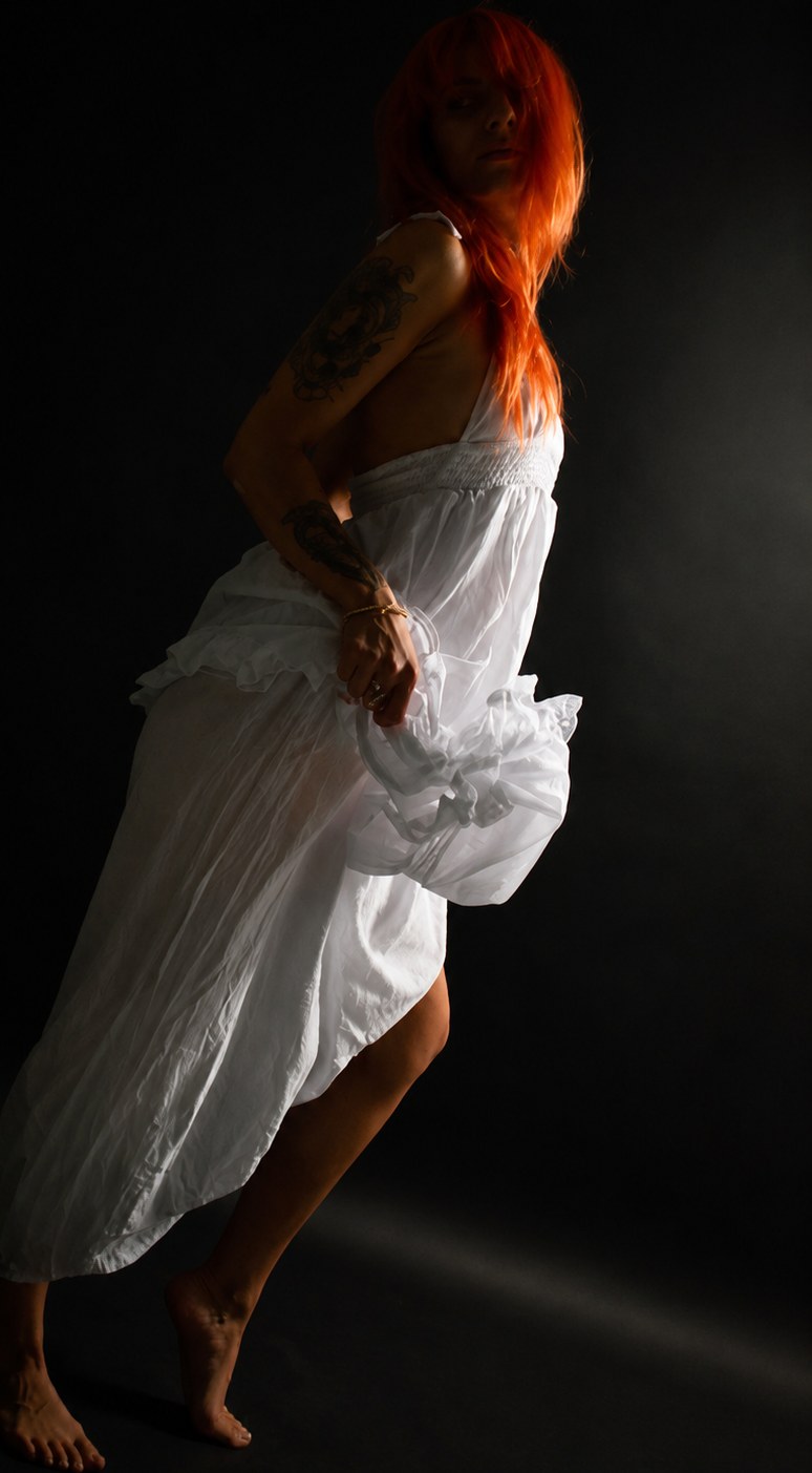 byliv in a flowing white dress in dramatic studio light